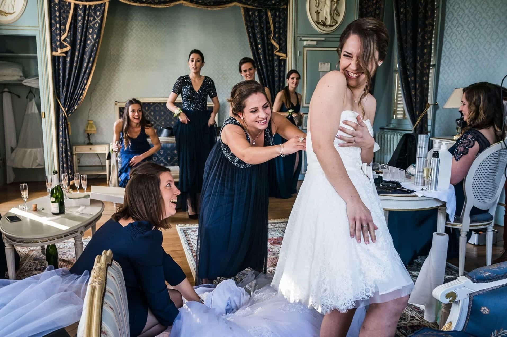 Marié riant aux éclats entourée de ses témoins lors du passage de sa robe au château de Vilette