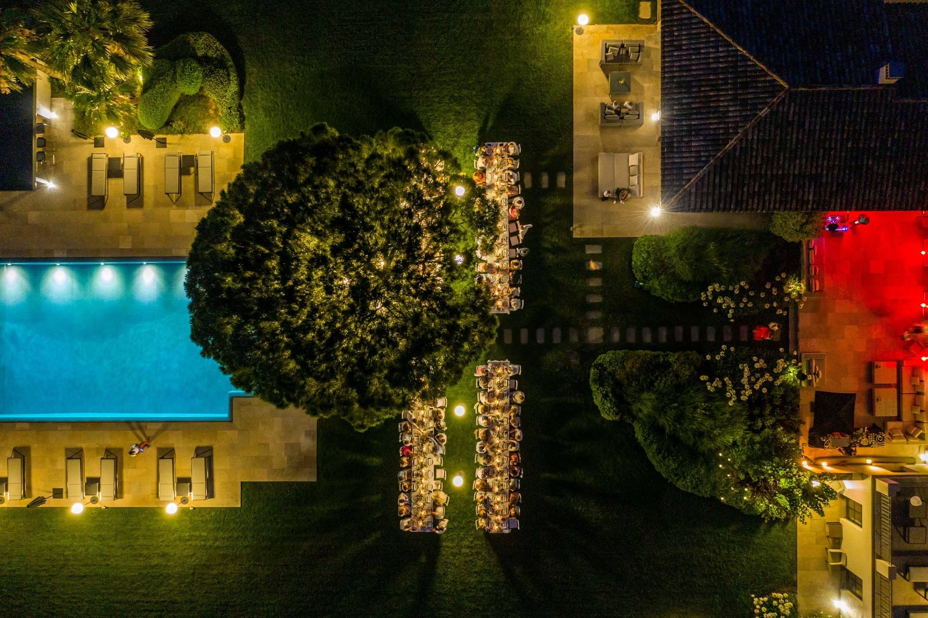 Vue aerienne d'un diner de mariage en exterieur entre la maison familiale et la piscine