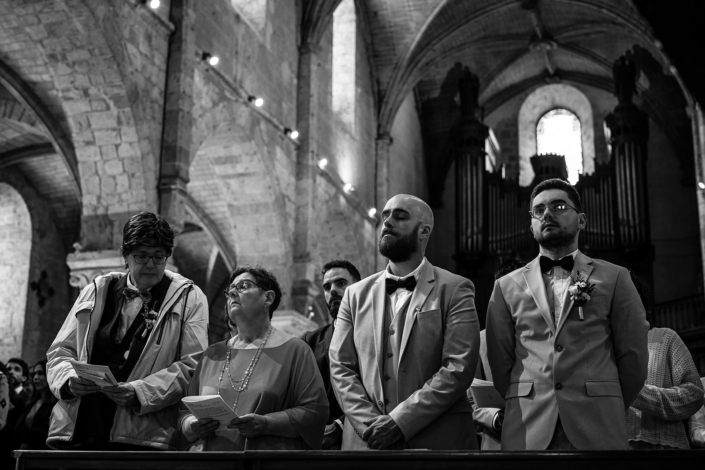 Invités pendant la cérémonie religieuse, en noir et blanc – église Notre-Dame de Beaugency, mariage de Pauline et Boris