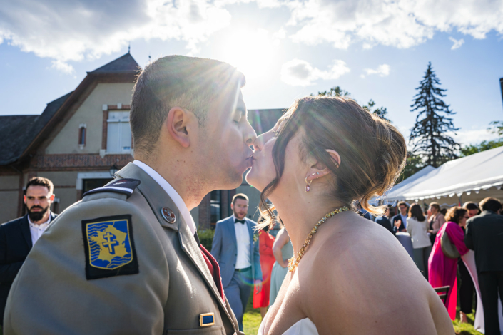 Baiser des mariés à contre-jour – mariage de Pauline et Boris aux Écuries de Sologne